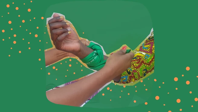 Woman tying a green scarf, symbolising abortion rights, around another feminists arm in Zambia.