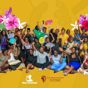 Group picture from Decolonizing the Internet: East Africa showing more than 30 African feminists and allies from the convening with their arms raised and holding up placards with feminist slogans.